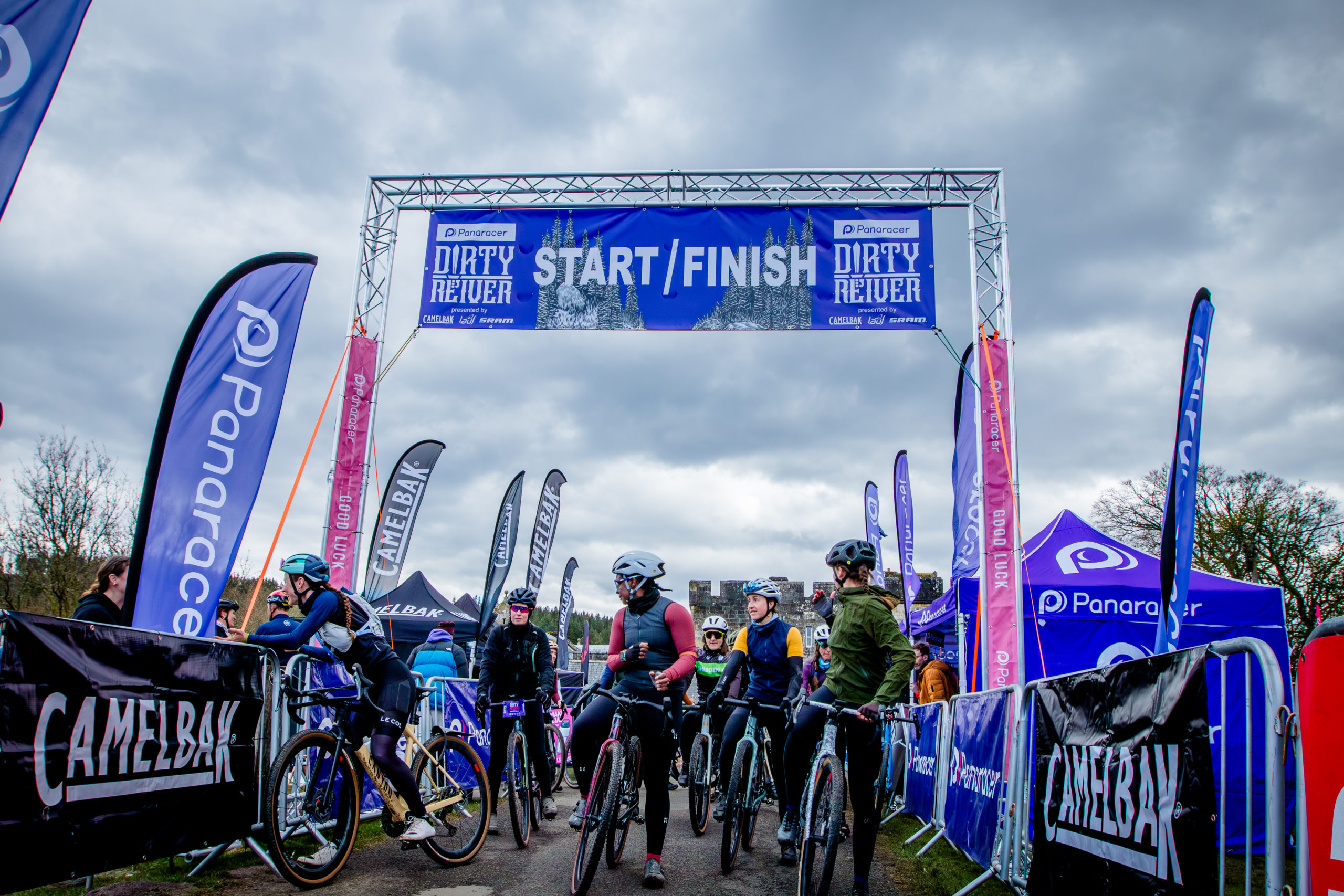 Stage Concepts - Focal Events’ Dirty Reiver Race - cyclists under a truss archway that signifies the start and finish line of the event